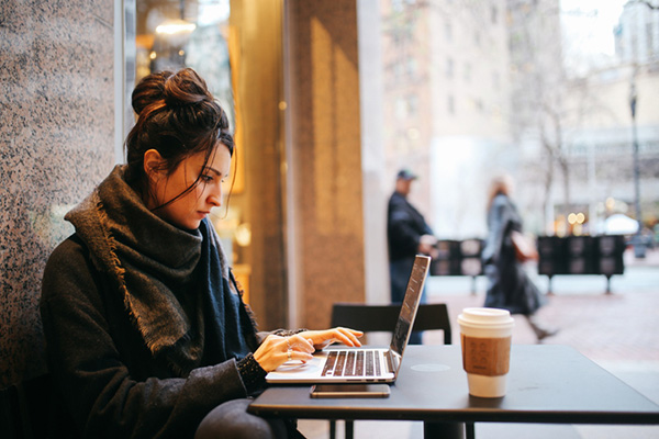 Young woman doing work on a laptop outside