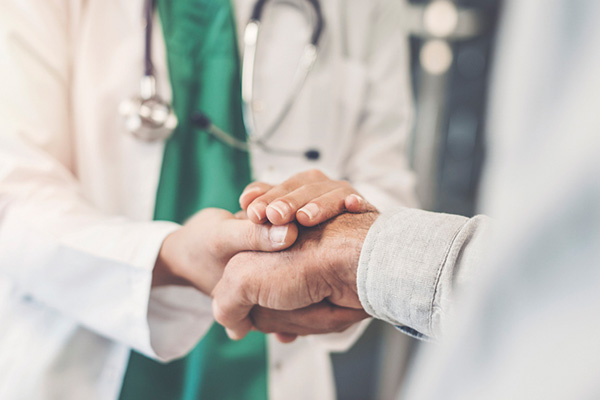 Health worker holding patient's hand